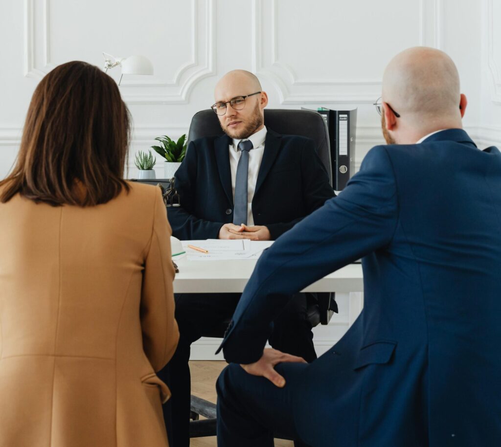 A lawyer consults a couple on divorce proceedings in an elegant office setting.